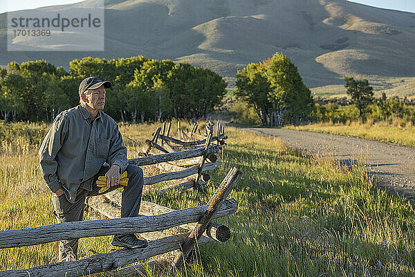 USA  Idaho  Bellevue  Landwirt lehnt an Zaun auf Feld