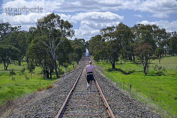 Australien  New South Whales  Frau wandert entlang der Bahnstrecke