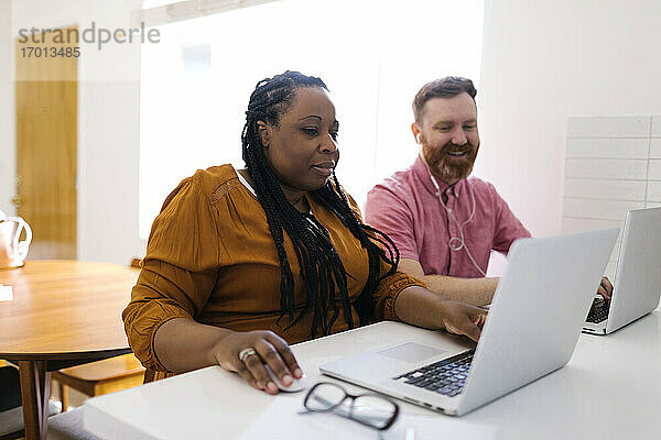 Mann und Frau arbeiten mit Laptops im Home-Office