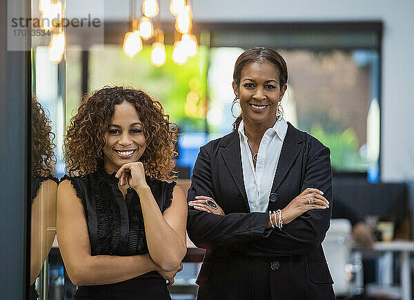 Porträt von zwei lächelnden Geschäftsfrauen im Büro stehend