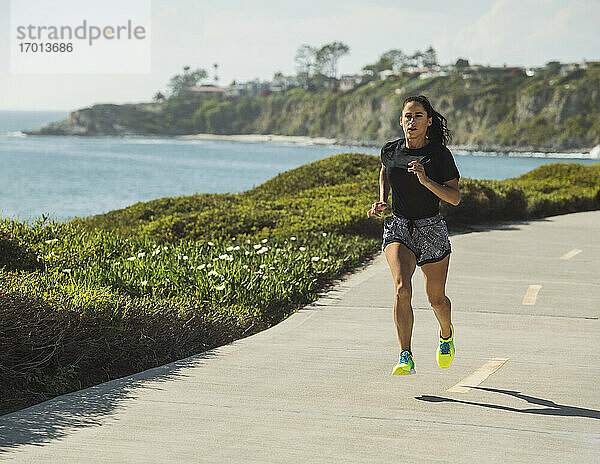 USA  Kalifornien  Dana Point  Frau läuft auf der Straße an der Küste