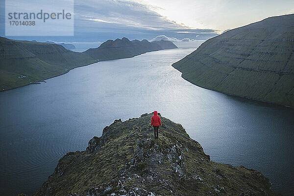 Dänemark  Färöer Inseln  Klaksvik  Frau steht auf Klakkur Berg und schaut auf Fjord