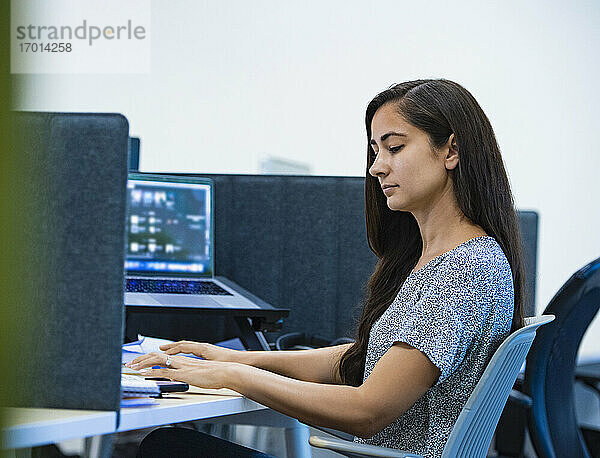 Frau mit Computer am Schreibtisch im Büro