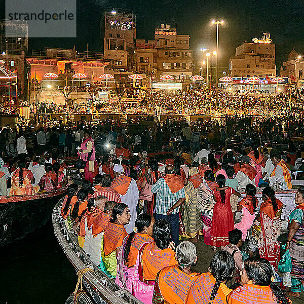 Varanasi (ex-Bénares)  Uttar Pradesh  Indien. Jeden Abend versammelt sich eine Schar von Pilgern und Neugierigen auf den Stufen  aber auch auf Booten  um die Zeremonie zu verfolgen  die direkt über dem Ghat stattfindet. Der Fluss Ganges wird in ganz Indien als Göttin angesehen und ist eine wichtige Gottheit im hinduistischen Pantheon. Das Ganga Aarti  ein Ritual zur Vertreibung der Dunkelheit  ist mehr als 2000 Jahre alt und findet jeden Abend bei Sonnenuntergang in Varanasi statt.