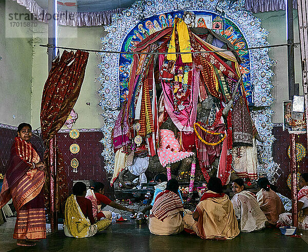 Stadt Kalna  Westbengalen  Indien. Die Gläubigen bringen der Hindu-Gottheit Durga in Kalna Opfergaben vor dem Altar dar. Die Statue ist mit farbigen Stoffen bedeckt.