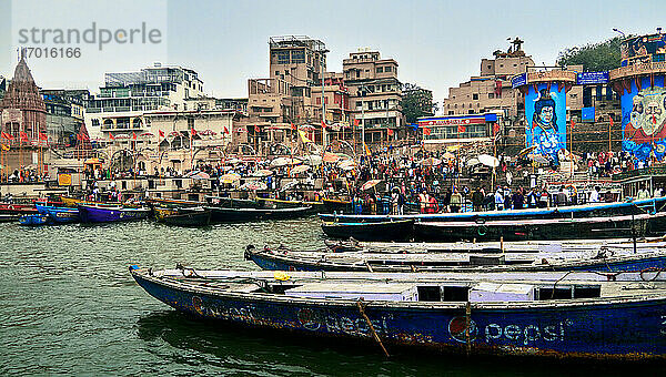 Varanasi (ex-Bénares)  Uttar Pradesh  Indien . DVaranasi (ex-Bénares)  Indien. 15. März 2020. Der Ganges in Varanasi  der heiligsten Stadt Indiens  in die Pilger  Hindus und Touristen kommen  um den heiligen Fluss zu besuchen  zu baden  zu meditieren  zu verehren und ihre Toten einzuäschern. Es ist auch der Ort  an dem sich die Ghats mit Terrassen  Palästen  Stufen und Palvillions seit dem 7. Blaue Säulen zeigen Bilder von Göttern  die in der hinduistischen Religion verehrt werden