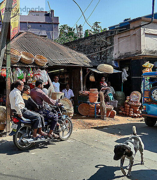 Kalna  Westbengalen  Indien. Typische Atmosphäre im Zentrum mit seinen Ständen entlang der Straße. Händler von Körben  verschiedene Töpfereien und Verkehr auf der Straße.