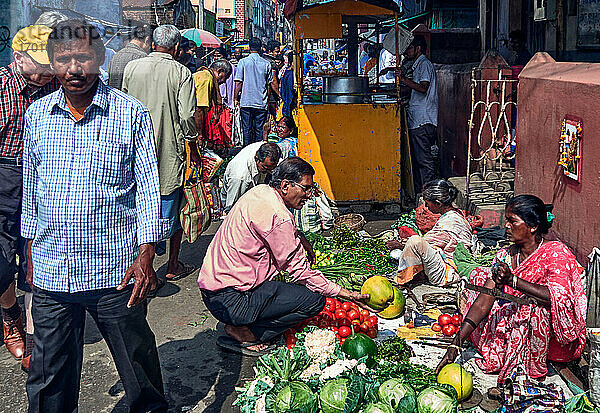 Chandannagar  Westbengalen  Indien: Die Käufer gehen an einer Marktstraße vorbei  während verschiedene Verkäufer an ihren Ständen und manchmal sogar auf dem Boden in der Altstadt von Chandannagar verschiedene Arten von Lebensmitteln  Obst und Gemüse verkaufen