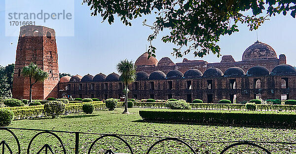 Stadt Murshidabad. Westbengalen  Indien. Gelegen in Murshidabad  der mittelalterlichen Hauptstadt von Bengalen  ist die Katra-Moschee ein riesiges Bauwerk  das von Nawab Murshidkuli Khan in den Jahren 1723-25 errichtet wurde. Erbaut als Nachbildung der heiligen Kaba-Moschee von Mekka  ist diese riesige Moschee ein hervorragendes Beispiel für mittelalterliche muslimische Architektur in Bengalen. Das Grab dieses Moguls befindet sich unter der Zugangstreppe. Die Moschee wurde 1897 durch ein Erdbeben schwer beschädigt. Die Moschee verfügt heute über zwei 22 Meter hohe Minars und zwei riesige Kuppeln mit einem Durchmesser von 15 Metern. Im Inneren gibt es eine große Lichtung  auf der die Gläubigen ihr Gebet verrichten können. Der Eingang hat 16 kleinere Kuppeln.