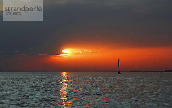 Silhouette eines Segelboots auf dem Bodensee bei stimmungsvollem Sonnenuntergang