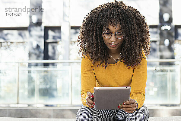 Junge Frau benutzt digitales Tablet im Freien