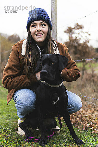 Junge Frau mit Hund in Herbstlandschaft