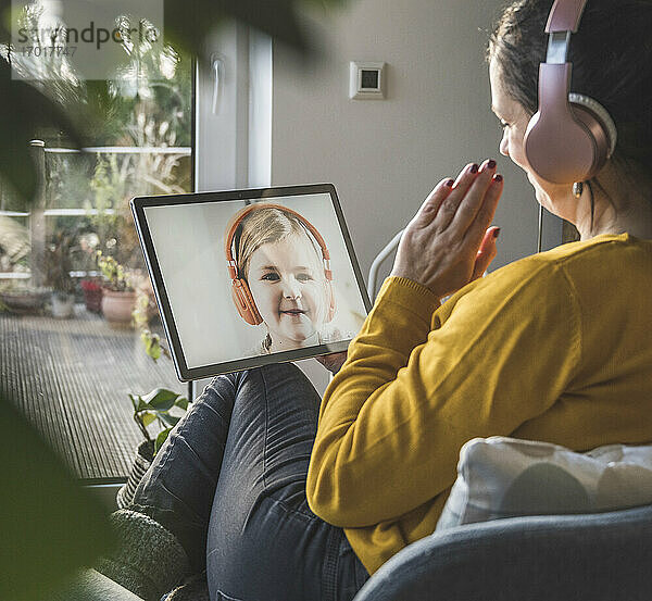 Frau im Gespräch mit kleinem Mädchen während eines Videoanrufs auf einem digitalen Tablet