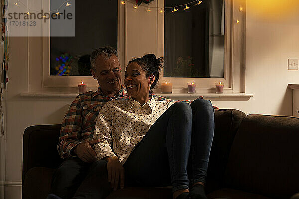 Lächelndes Paar  das sich auf dem Sofa zu Hause entspannt