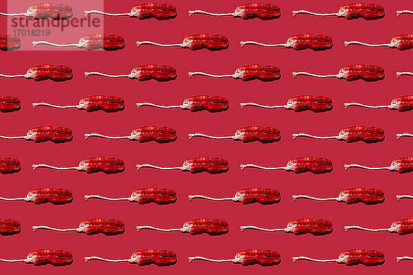 Muster aus gebrauchten Tampons vor rotem Hintergrund