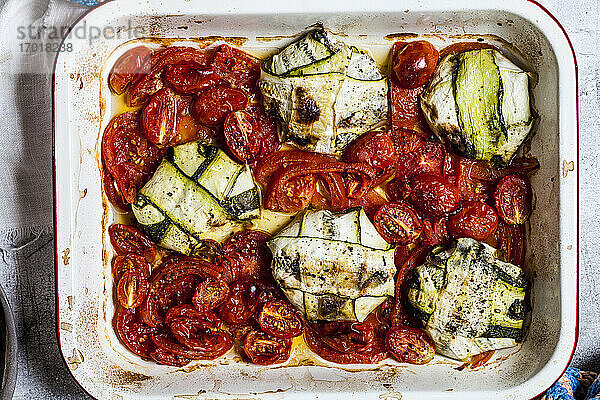 Gegrillte Tomaten mit Spinat und Feta-Käse gefüllte Zucchini-Ravioli in einem Teller auf dem Tisch
