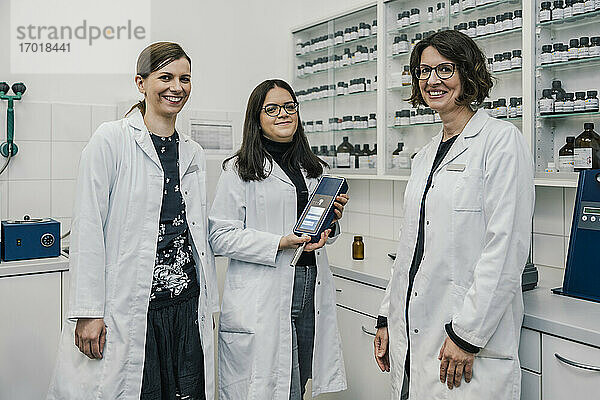 Lächelnde Apothekerinnen mit NIR-Spektrometer in einer Drogerie