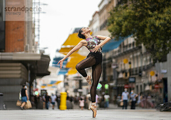 Tänzerin übt Ballett tanzen  während stehend Zehenspitzen auf der Straße in der Stadt
