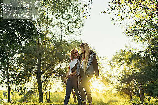 Lesbisches Paar hält sich beim Spaziergang im Wald an den Händen
