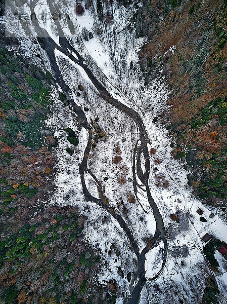 Luftaufnahme eines Flusses  der durch eine schneebedeckte Landschaft fließt
