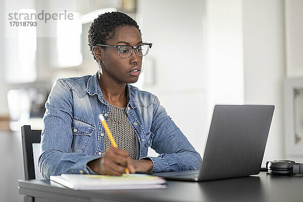 Frau arbeitet zu Hause am Laptop