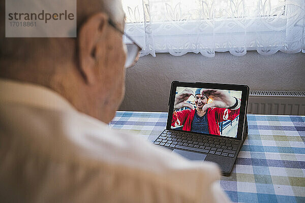 Großvater spricht mit Enkelin per Videoanruf über Laptop zu Hause