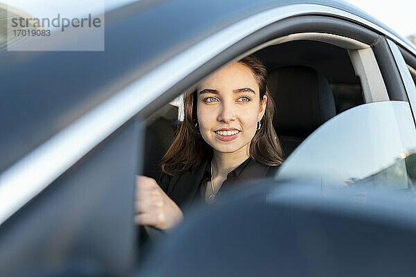 Geschäftsfrau lächelnd beim Autofahren