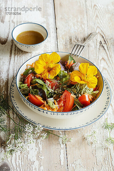 Schüssel mit vegetarischem Salat mit essbaren Blumen