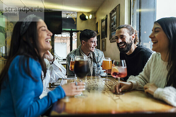 Lächelnde Freunde bei einem Drink im Restaurant