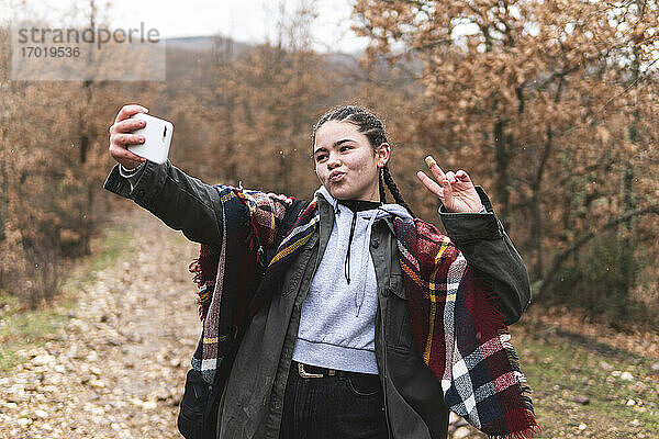 Teenager-Mädchen nimmt Selfie in Herbstlandschaft
