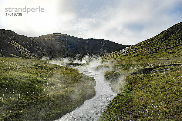 Der Thermalfluss Reykjadalur fließt durch ein Tal in Island