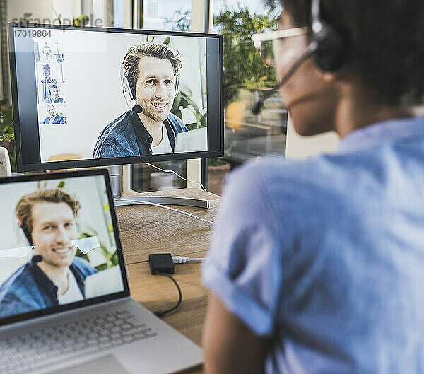 Frau hält Videokonferenz mit Mann über Laptop zu Hause