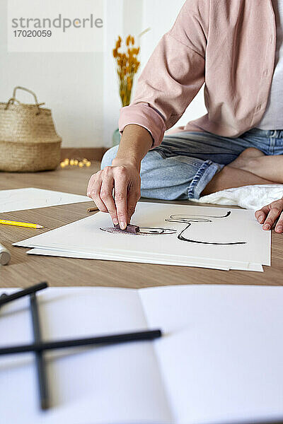Künstlerin  die zu Hause mit Kohle auf Papier zeichnet