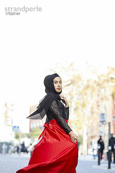 Porträt der jungen schönen Frau trägt Hijab und langen Rock posiert in der Mitte der Stadt Straße