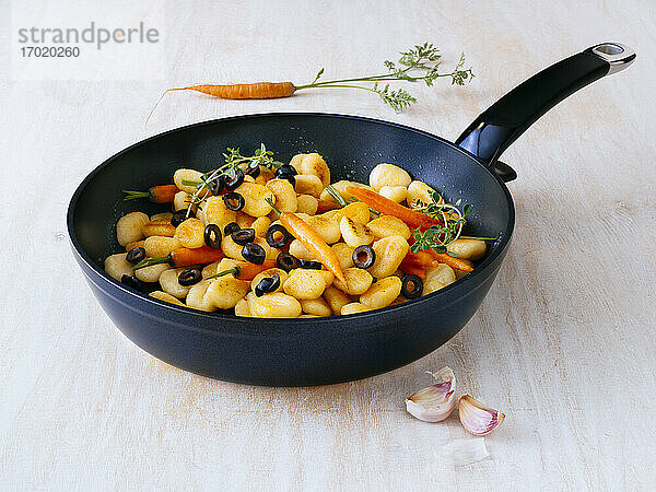 Bratpfanne mit italienischen Gnocchi mit Oliven und Karotten