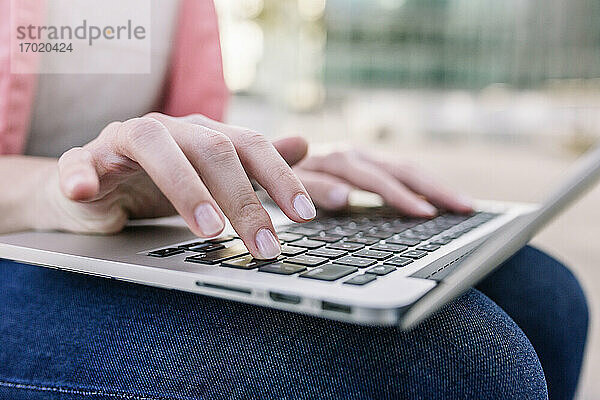 Hände einer Geschäftsfrau mit Laptop im Freien