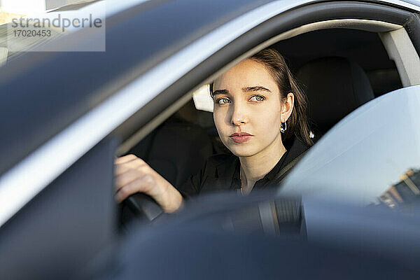 Geschäftsfrau schaut beim Autofahren weg
