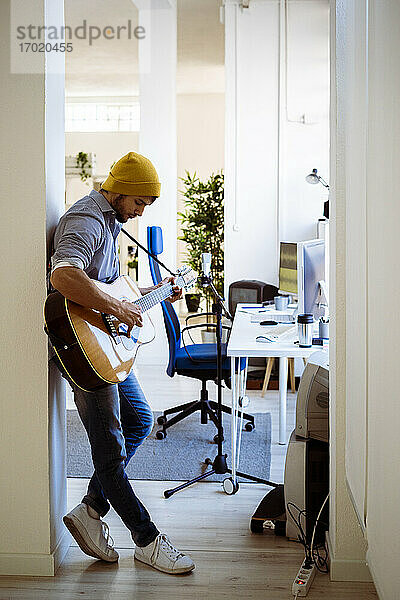 Gitarrist spielt Gitarre im Stehen im Studio