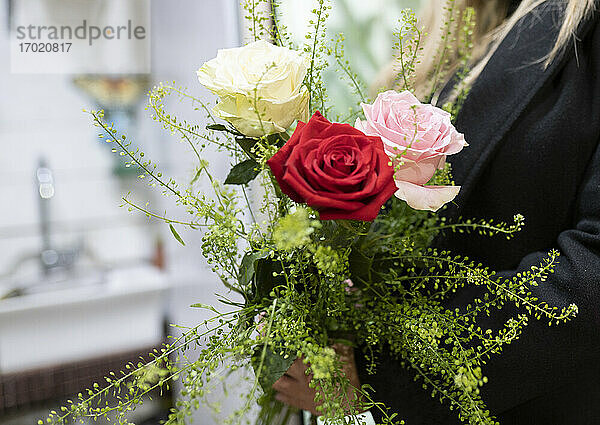 Floristin hält Blumenstrauß mit Rosen