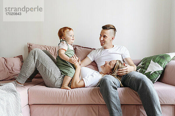 Glückliche Familie mit kleiner Tochter entspannt auf dem Sofa