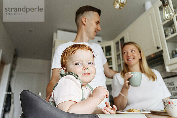 Glückliche Familie mit kleiner Tochter am Küchentisch