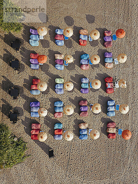 Luftaufnahme von Reihen von Sonnenschirmen und Liegestühlen am leeren Kuta Beach  Bali  Indonesien
