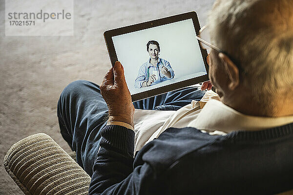 Ein älterer Mann lässt sich von einer Allgemeinmedizinerin per Videoanruf über ein digitales Tablet beraten