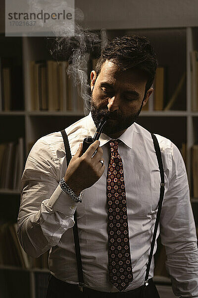 Porträt eines bärtigen Mannes  der Pfeife raucht