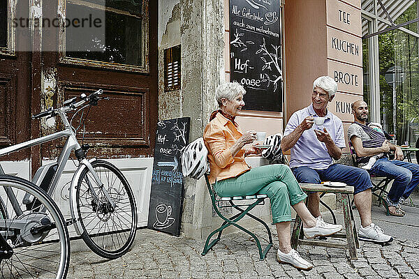Touristen mit Elektrofahrrad beim Kaffeetrinken in der Altstadt von Dresden  Deutschland