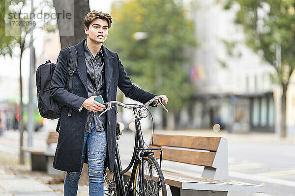 Hübscher junger Mann auf dem Fahrrad in der Stadt