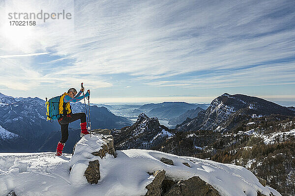 Männlicher Wanderer klettert auf dem Gipfel eines Berges gegen den Himmel  Orobische Alpen  Lecco  Italien