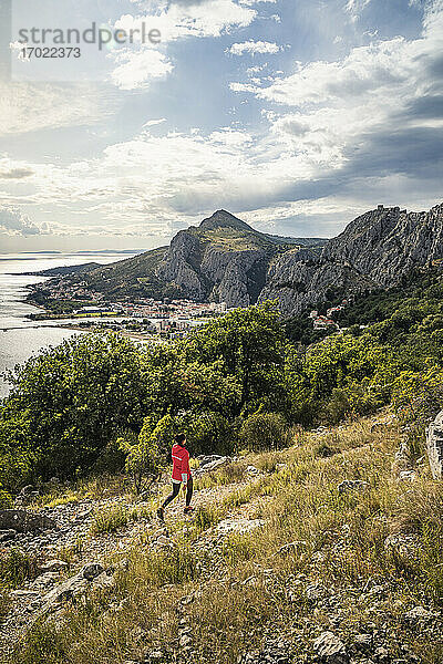 Frau beim Wandern in der Landschaft am Meer