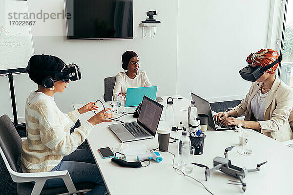 Kollegen benutzen Virtual-Reality-Headsets im Büro
