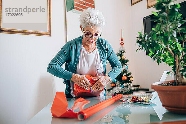 Frau verpackt Weihnachtsgeschenke Freigegeben (PR)esents